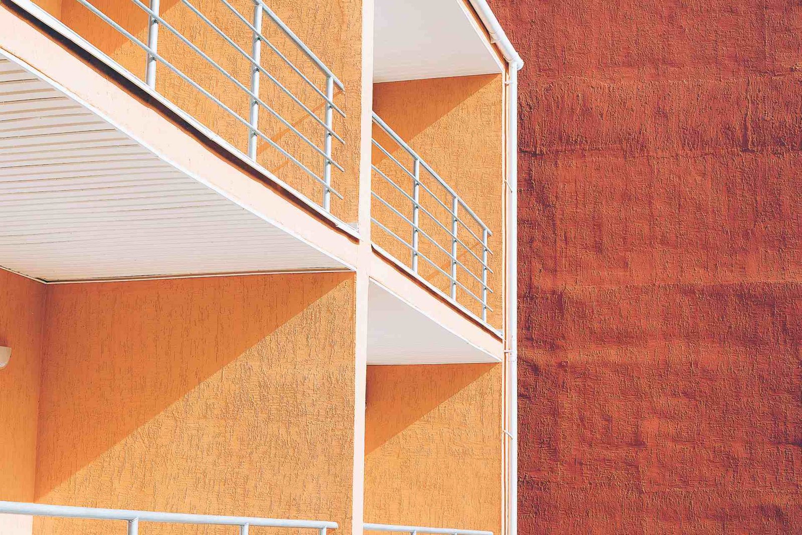 Workers installing ETICS insulation boards on building facade with scaffold